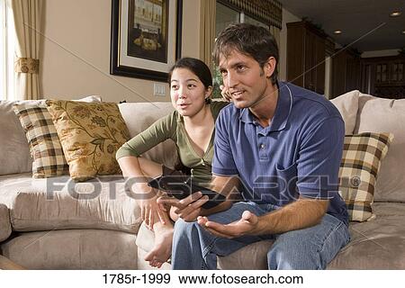 Father and daughter on sofa watching TV View Large Photo Image Stock Photo - Father and daughter on sofa watching TV. Fotosearch