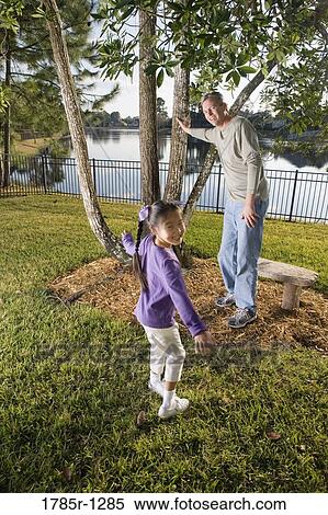 Stock Photography - Father and daughter playing in backyard. Fotosearch