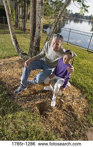 Father and daughter sitting in backyard View Large Photo Image Stock Photograph - Father and daughter sitting in backyard. Fotosearch