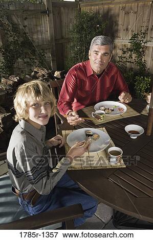 Stock Photo - Father and son eating sushi. Fotosearch