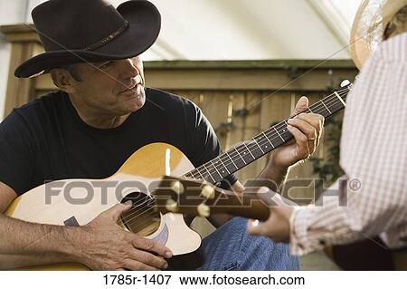 Stock Photo - Father and son playing guitar, country music. Fotosearch