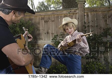 Father and son playing guitar together View Large Photo Image Stock Image - Father and son playing guitar together. Fotosearch