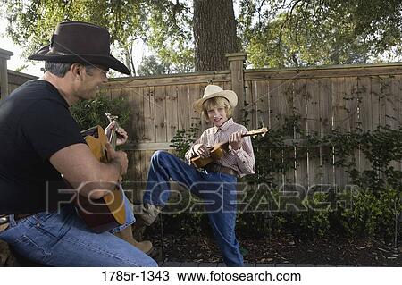 Father and son playing guitar together View Large Photo Image Stock Image - Father and son playing guitar together. Fotosearch