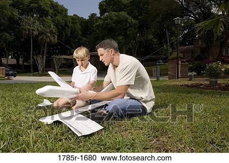 Stock Image - Father and son with a toy glider. Fotosearch