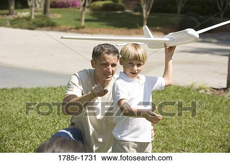 Father and son with a toy glider View Large Photo Image Stock Image - Father and son with a toy glider. Fotosearch