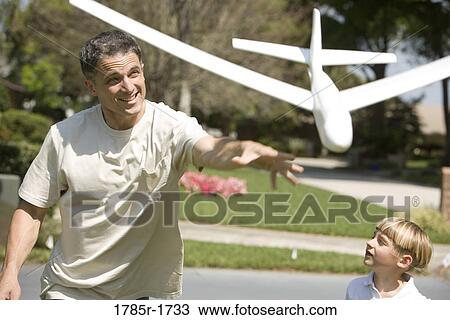 Stock Image - Father and son with a toy glider. Fotosearch