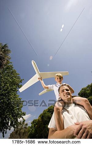 Father and son with a toy glider View Large Photo Image Stock Photograph - Father and son with a toy glider. Fotosearch