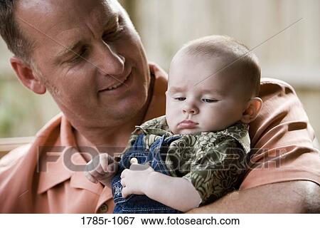 Stock Photo - Father holding his baby. Fotosearch