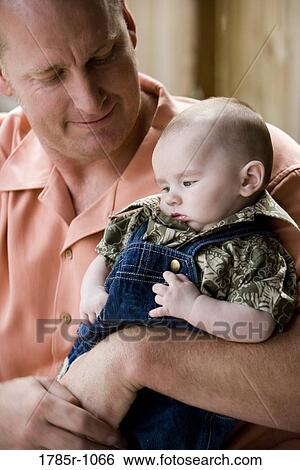 Stock Photograph - Father holding his baby. Fotosearch