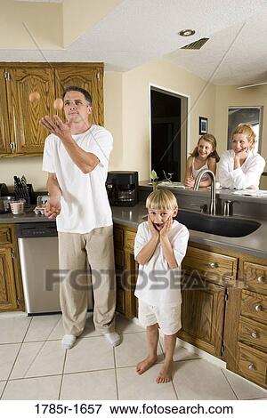 Father juggling eggs with family in kitchen View Large Photo Image Stock Photo - Father juggling eggs with family in kitchen. Fotosearch