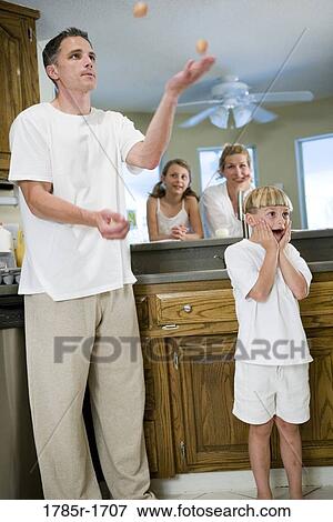 Father juggling eggs with family in kitchen View Large Photo Image Stock Photo - Father juggling eggs with family in kitchen. Fotosearch