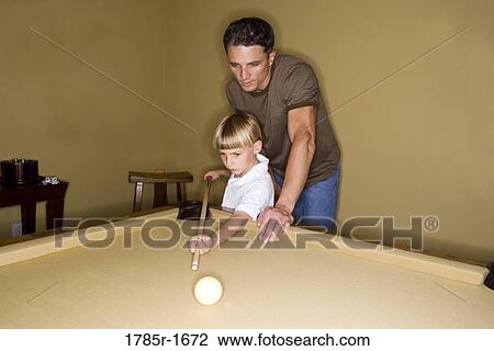 Father showing his young son how to play pool View Large Photo Image Stock Image - Father showing his young son how to play pool. Fotosearch