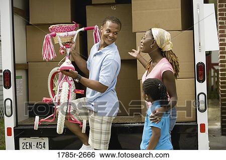 Father unloading a bicycle from a moving truck View Large Photo Image Stock Photograph - Father unloading a bicycle from a moving truck. Fotosearch