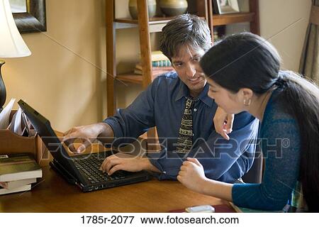 Father using laptop computer at home while his teenage daughter watches View Large Photo Image Stock Photo - Father using laptop computer at home while his teenage daughter watches. Fotosearch