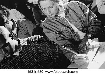 Stock Image - Female student cheating during an examination. Fotosearch