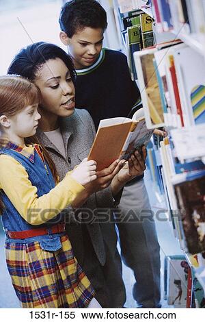 Female teacher reading a book with two students View Large Photo Image Stock Photography - Female teacher reading a book with two students. Fotosearch