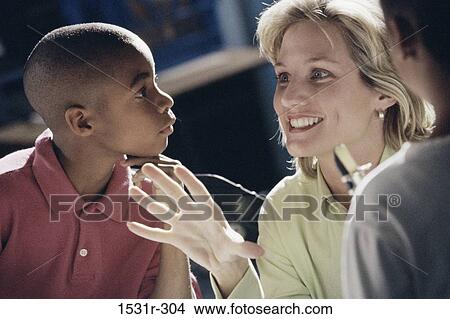 Female teacher talking to students in a class View Large Photo Image Picture - Female teacher talking to students in a class. Fotosearch