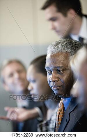 Stock Photo - Focus on African American business man in group meeting. Fotosearch