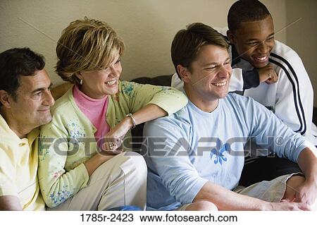 Stock Image - Four people sitting and watching. Fotosearch