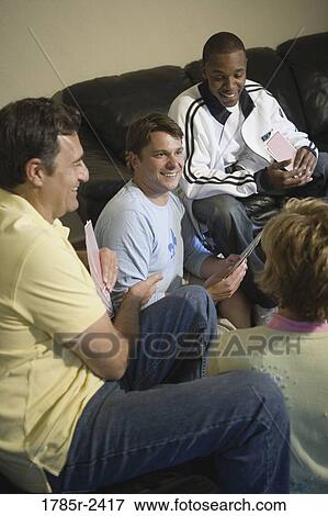 Stock Photo - Friends playing cards at home. Fotosearch
