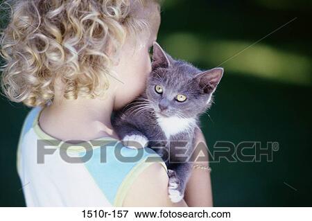 Girl carrying a kitten View Large Photo Image Stock Photo - Girl carrying a kitten. Fotosearch