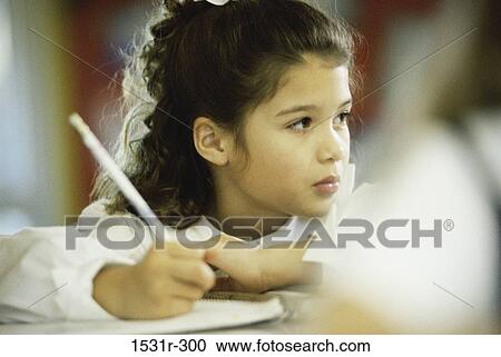 Girl holding a pencil looking sideways View Large Photo Image Stock Image - Girl holding a pencil looking sideways. Fotosearch