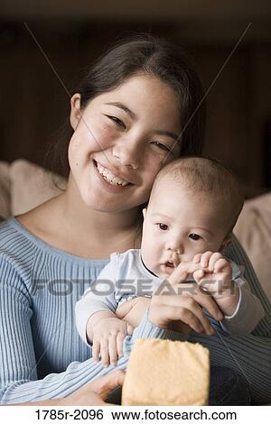 Girl holding her baby brother View Large Photo Image Stock Photograph - Girl holding her baby brother. Fotosearch