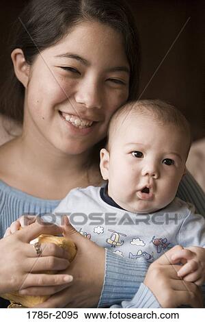 Stock Photography - Girl holding her baby brother. Fotosearch