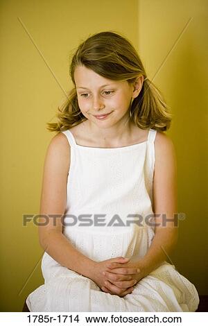 Girl sitting and looking downward View Large Photo Image Picture - Girl sitting and looking downward. Fotosearch