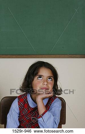 Girl sitting in a classroom and thinking View Large Photo Image Stock Photograph - Girl sitting in a classroom and thinking. Fotosearch