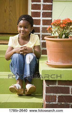 Girl sitting on steps outside house View Large Photo Image Stock Image - Girl sitting on steps outside house. Fotosearch