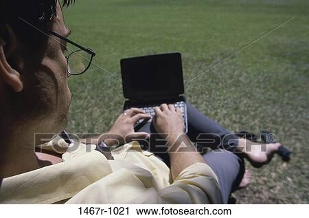 Stock Image - High angle view of a businessman working on a laptop computer. Fotosearch
