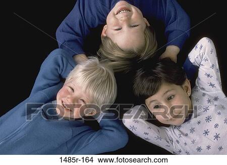 Picture - High angle view of two boys and a girl lying down. Fotosearch