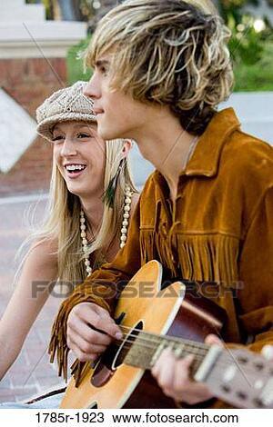 Stock Image - Hippie couple playing guitar. Fotosearch