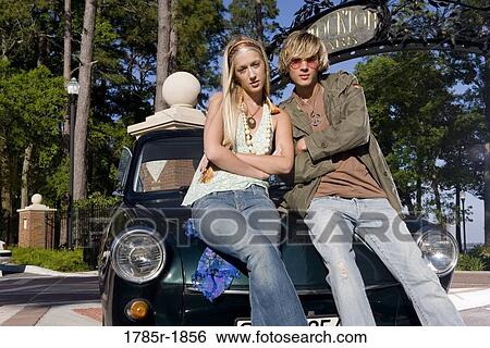 Hippie couple sitting on car hood View Large Photo Image Stock Photograph - Hippie couple sitting on car hood. Fotosearch