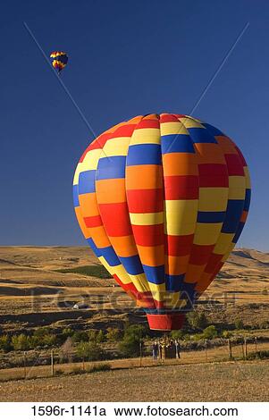 Stock Image - Hot air balloon over a landscape, Horse Heaven Hills, The Great Prosser Balloon Rally, Prosser, Washington State, USA. Fotosearch