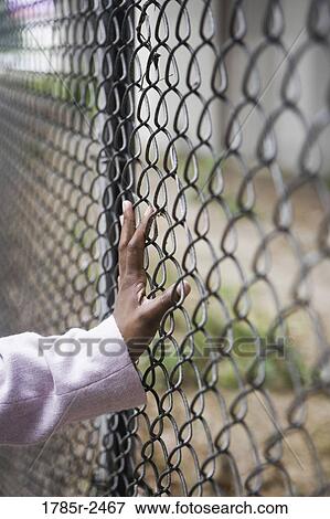 Stock Photo - Human hand on a fence. Fotosearch