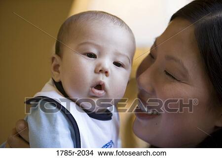 Infant boy being held by his mother View Large Photo Image Picture - Infant boy being held by his mother. Fotosearch