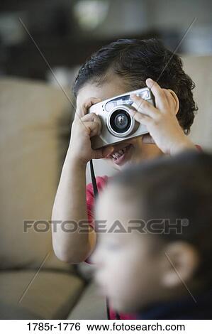 Little boy holding a camera View Large Photo Image Stock Photograph - Little boy holding a camera. Fotosearch