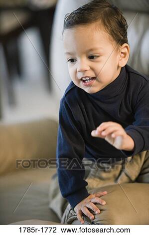 Little boy sitting on a sofa View Large Photo Image Stock Image - Little boy sitting on a sofa. Fotosearch
