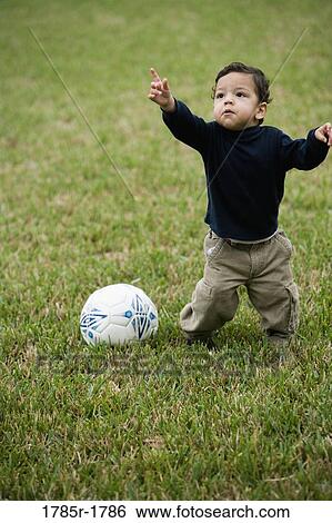 Little Hispanic boy on grass with soccer ball View Large Photo Image Stock Photograph - Little Hispanic boy on grass with soccer ball. Fotosearch