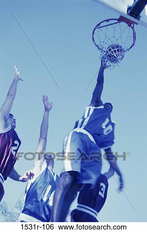 Low angle view of men playing basketball View Large Photo Image Stock Photograph - Low angle view of men playing basketball. Fotosearch