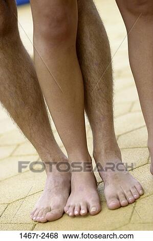 Stock Photo - Low section view of couples legs. Fotosearch