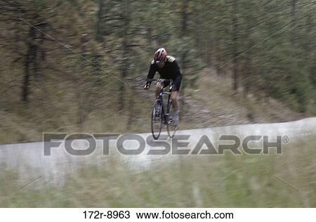 Man cycling on a bicycle View Large Photo Image Stock Image - Man cycling on a bicycle. Fotosearch
