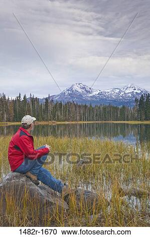 Man sitting on a rock at the lakeside, Scott Lake, Three Sisters, Willamette National Forest, Oregon, USA View Large Photo Image Stock Image - Man sitting on a rock at the lakeside, Scott Lake, Three Sisters, Willamette National Forest, Oregon, USA. Fotosearch