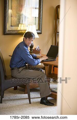 Man using laptop computer in the study of his home View Large Photo Image Stock Photography - Man using laptop computer in the study of his home. Fotosearch