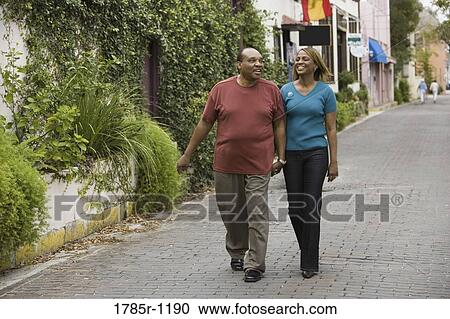 Stock Image - Mature African American couple strolling down street. Fotosearch