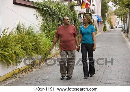 Stock Image - Mature African American couple strolling down street. Fotosearch