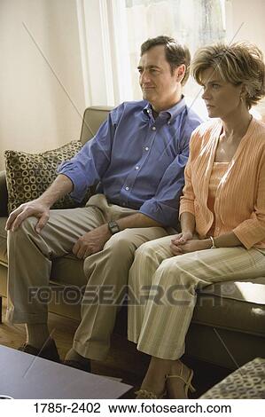 Mature couple sitting together on a sofa View Large Photo Image Stock Image - Mature couple sitting together on a sofa. Fotosearch