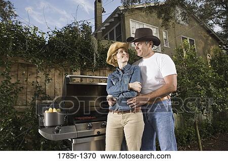 Mature couple standing together near barbeque grill View Large Photo Image Stock Image - Mature couple standing together near barbeque grill. Fotosearch
